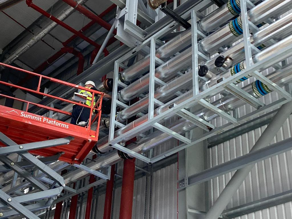 Prefabricated pipe-rack module being installed from an access platform