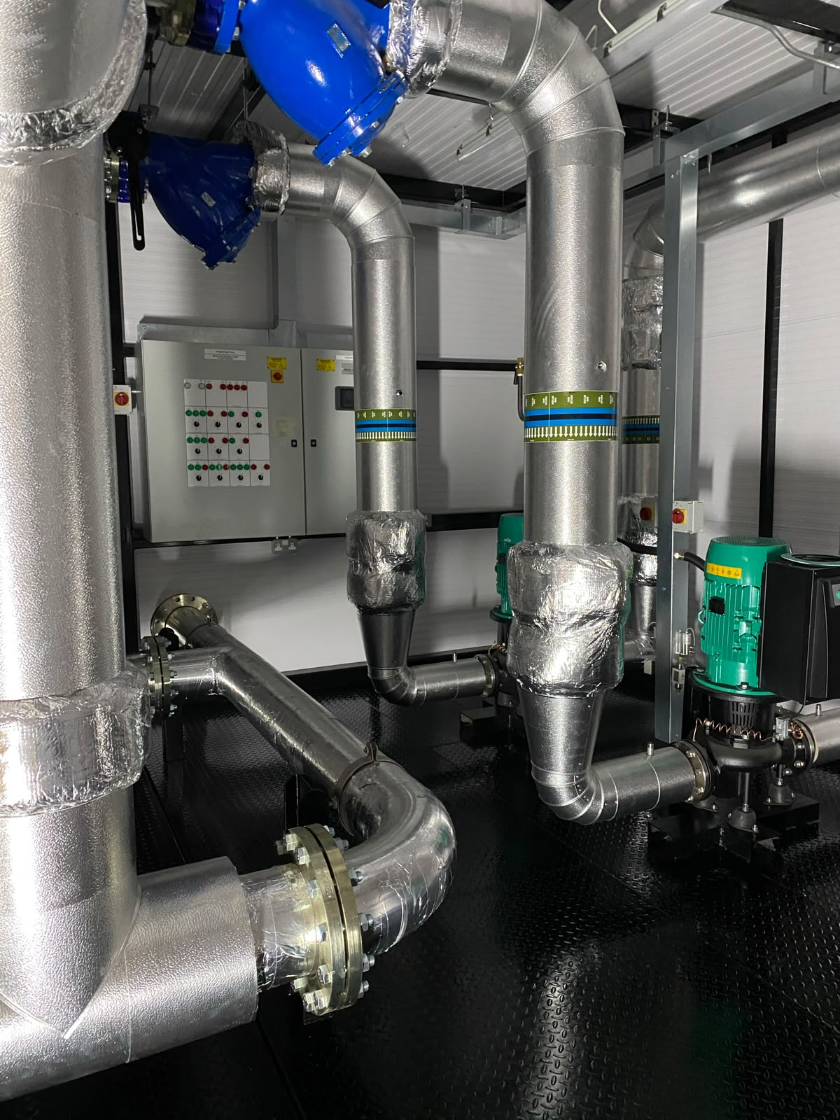 Insulated pump and pressurisation skid with controls inside a packaged module